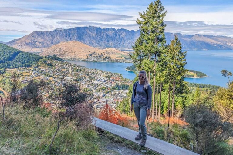 Bailey poses for a photo with views of Queenstown and Lake Wakatipu on the Tiki Trail