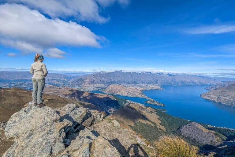 Bailey stands at the summit of Ben Lomond and overlooks Queenstown, New Zealand