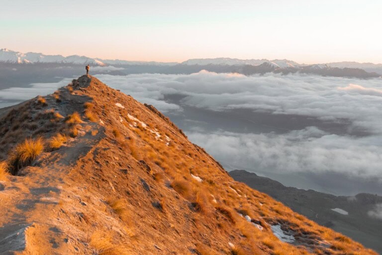 The famous Roy's Peak with a person at the end at sunrise in Wanaka