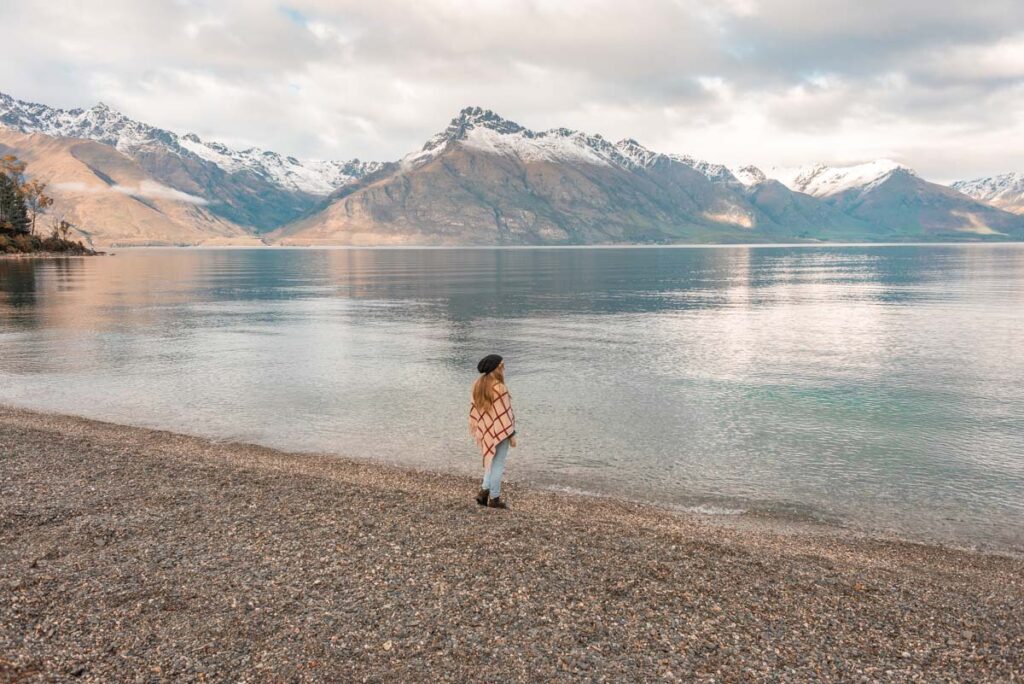 A lady walks the shoreline at Wilsons Bay, Queenstown-Glenorchy highway