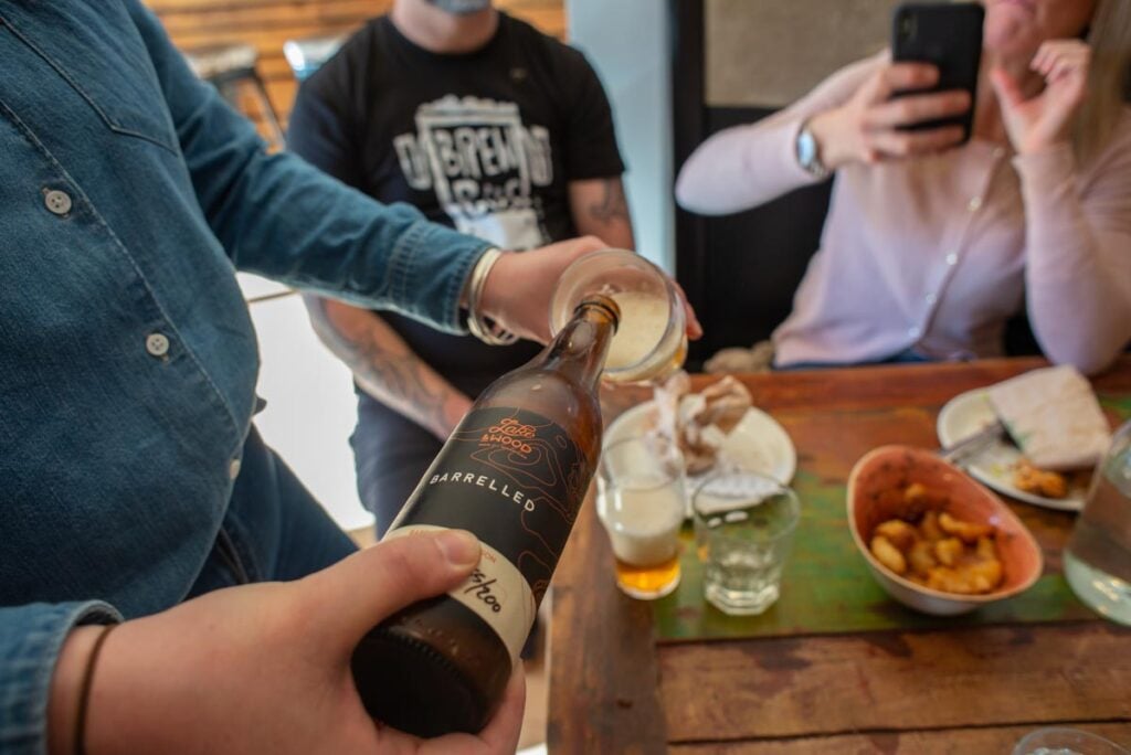 Pouring a bottle of Lake and Wood Beer Co at Slow Cuts in Arrowtown