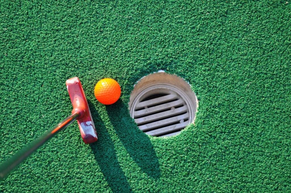 A putter and ball on a mini golf course