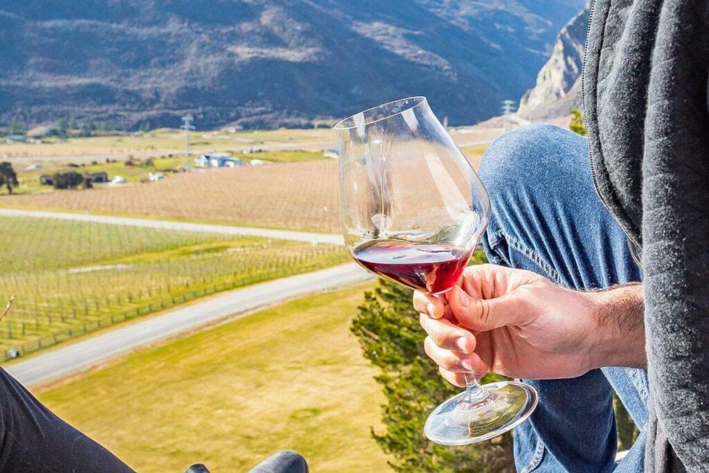 A glass of wine with views over Mt Rosa Winery near Queenstown
