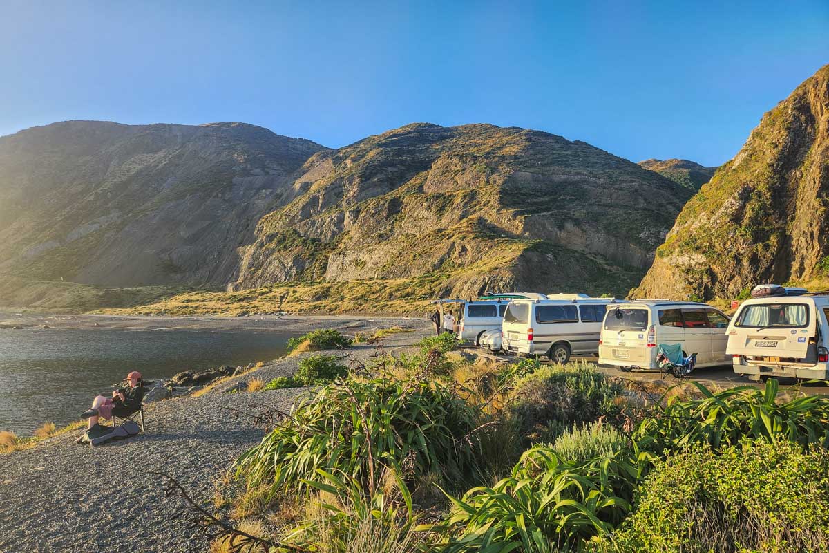 Campervans at Owhiro Bay at sunset in Wellington, NZ