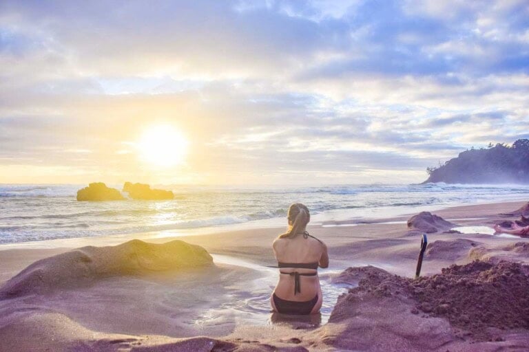 A lady relaxes at Hot Water Beach on the Coromandel, New Zealand
