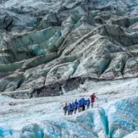 A group of tourists walk on the Franz Josef Glacier on a tour