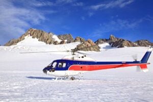 A helicopter lands on the Franz Josef Glacier at the beginning of a tour