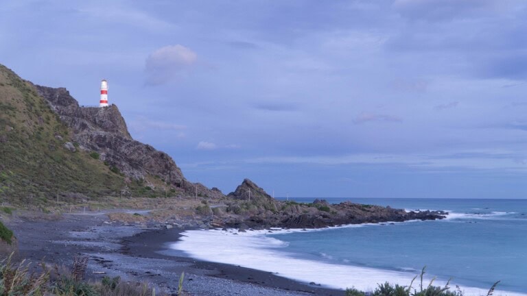 view of a bay at Cape Palliser and the lighthouse on the cliffs