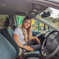 Bailey inside her rental car in New Zealand