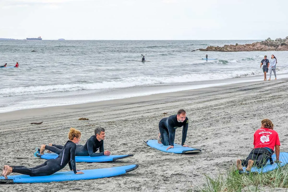 A group of people learn to surf in Mount Maunganui