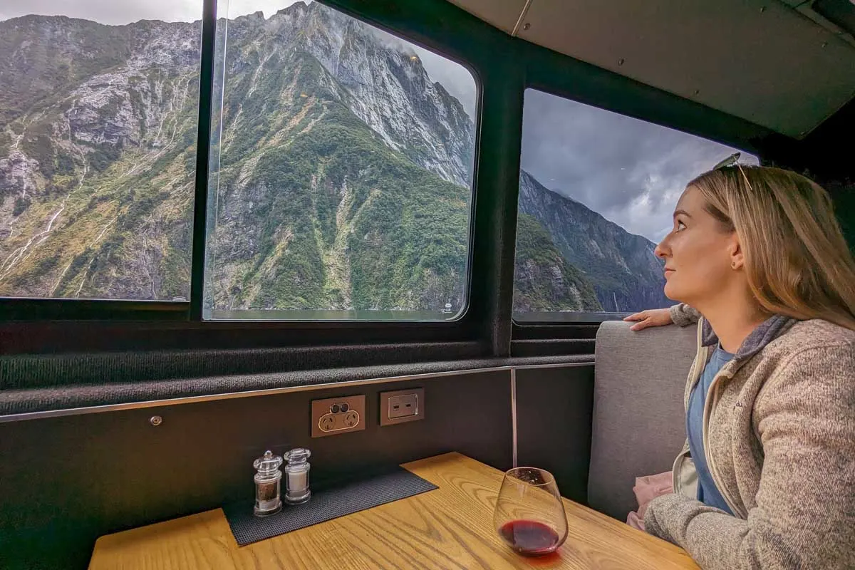 Bailey looks out the window at the views from a table on a Milford Sound cruise