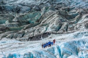 A group of tourists walk on the Fox Glacier