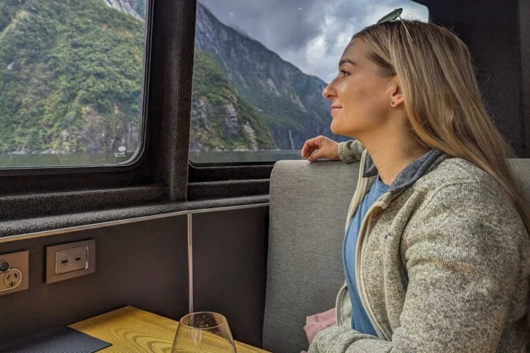 Bailey sits inside on a Doubtful Sound Overnight Cruise