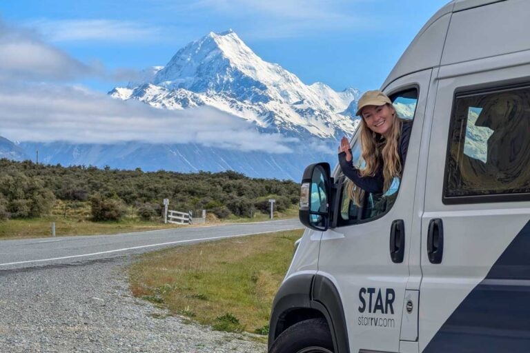 Bailey sits in a Star RV campervan in New Zealand with mountain in the background