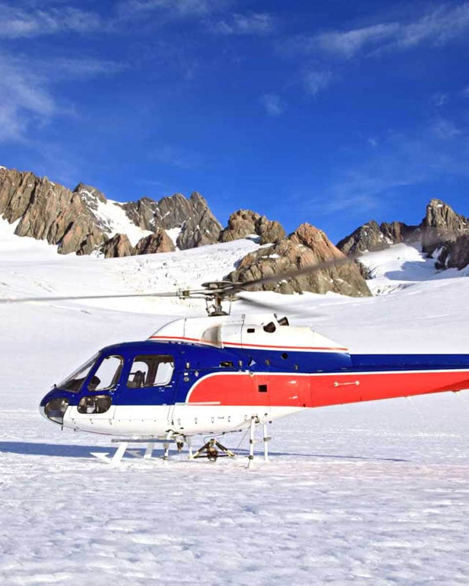 A-helicopter-lands-on-a-glacier-on-a-helicopter-tour-near Queenstown-New-Zealand