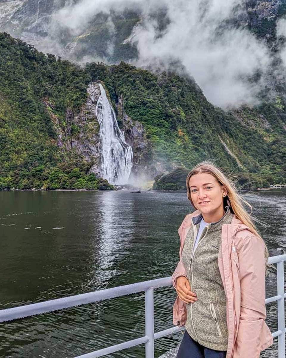 Bailey-on-a-Milford-Sound-cruise-with-Lady-Bowen-Falls-in-the-background on a tour from Queenstown New Zealand