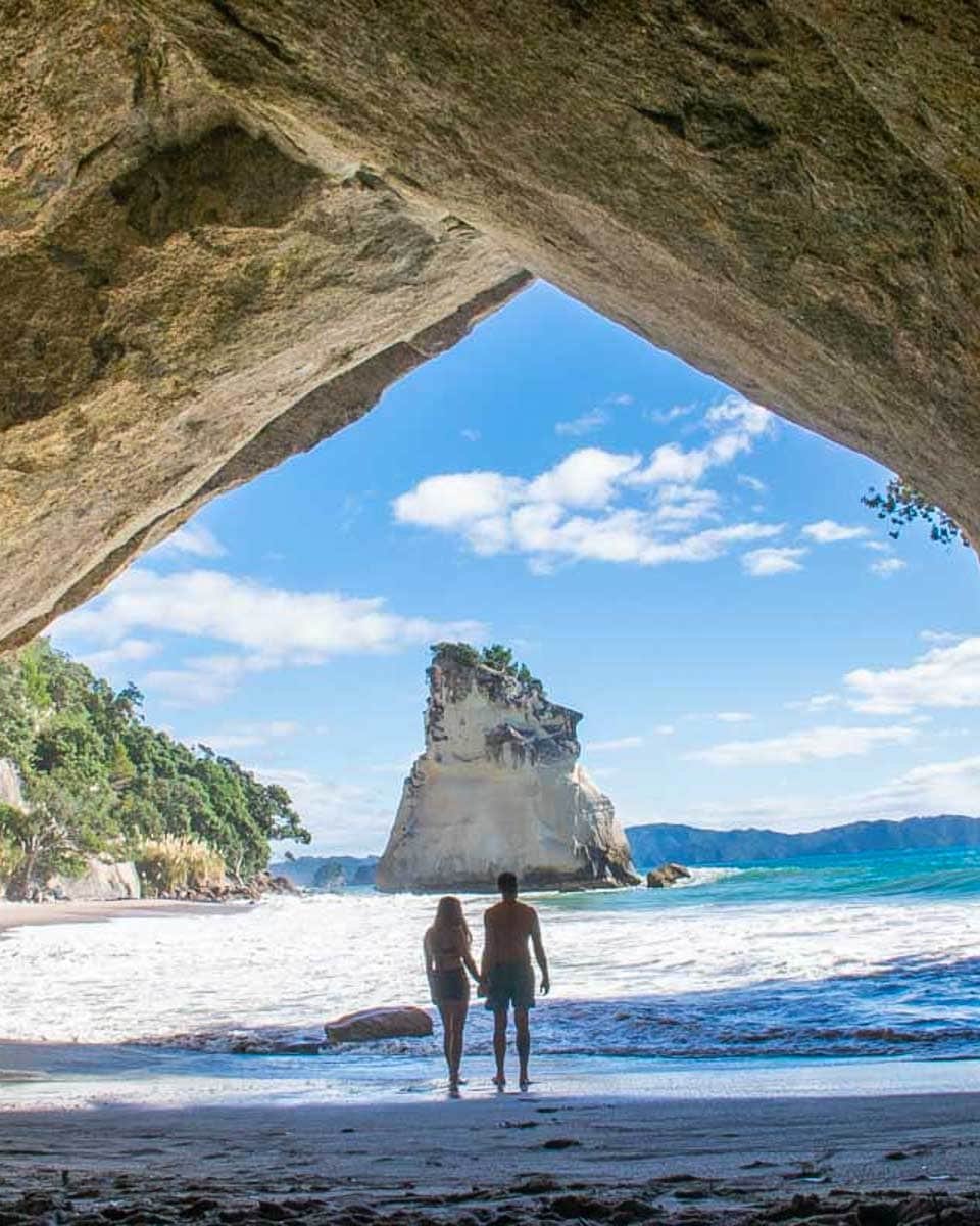 A-couple-take-a-photo-in-Cathedral-Cove-New-Zealand