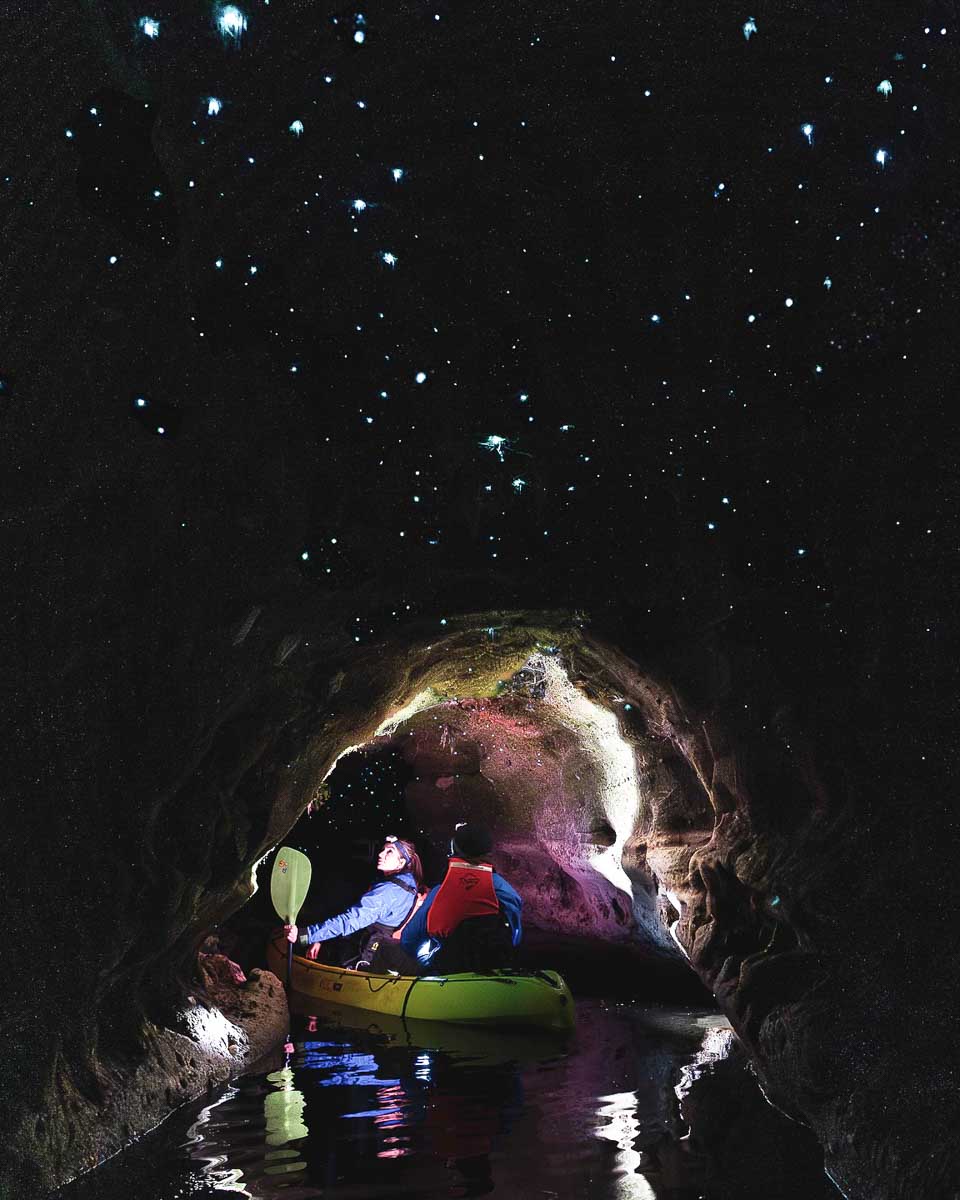 A person kayaks under glow worms on a tour in Rotorua